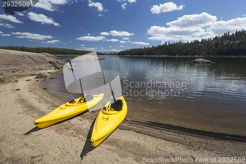 Image of Pair of Yellow Kayaks on Beautiful Mountain Lake Shore.