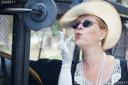 Image of Attractive Woman in Twenties Outfit Checking Makeup in Antique A
