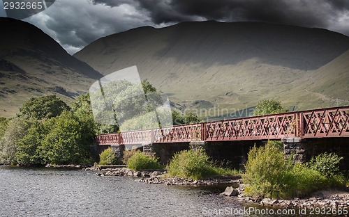 Image of Structure of metal railway bridge, stormy clouds