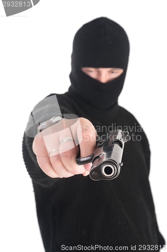 Image of masked man aims from gun in you. Focus on gun