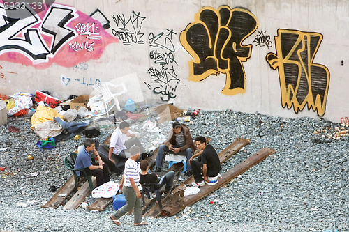 Image of Small group of men hanging out next to railway