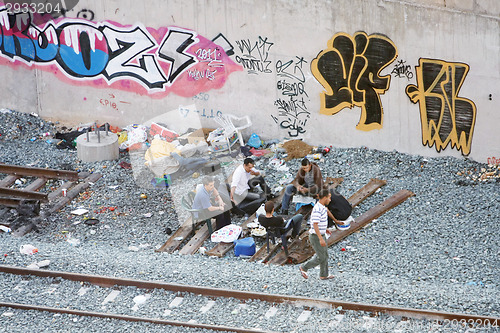 Image of Group of local men hanging out next to railway