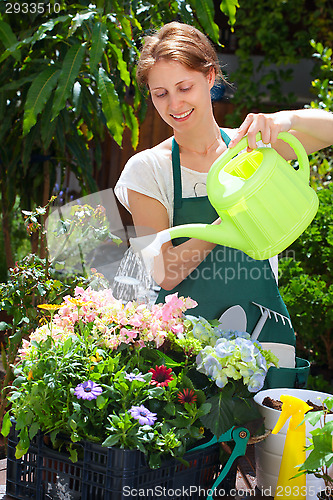 Image of Young woman gardening outdoor