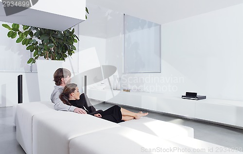 Image of young couple on sofa watching TV