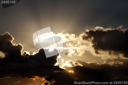 Image of Sunset sky with dark clouds and sun rays