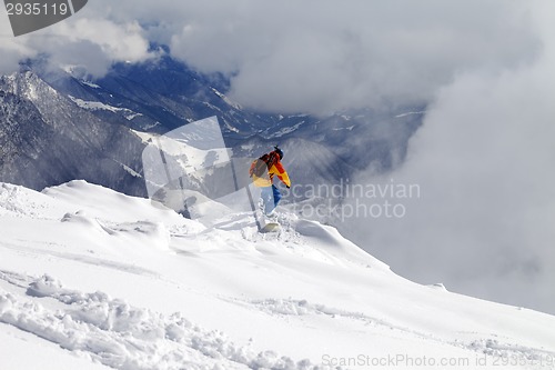 Image of Snowboarder on off-piste slope an mountains in fog