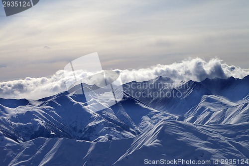 Image of Snowy mountains in mist at winter evening