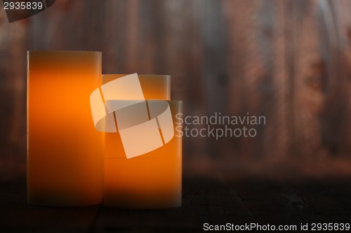 Image of Lit Candle on an Old Wooden Rustic Background