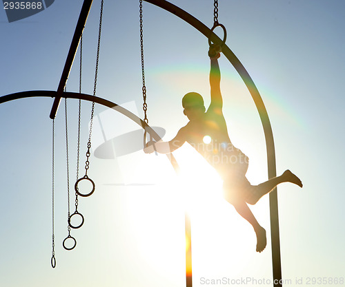 Image of Man Using Rings at the Beach With Lensflare