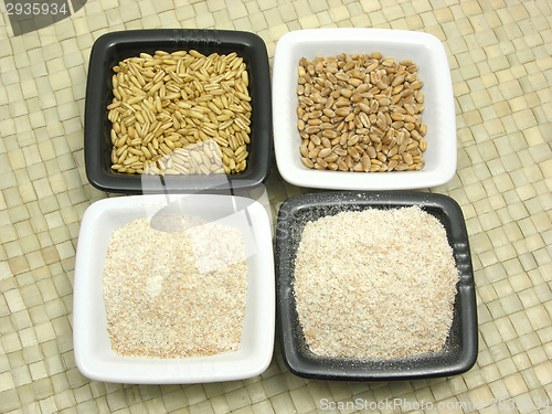 Image of Bowls of chinaware with cereal and wholemeal on rattan mat