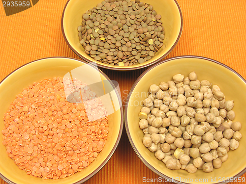 Image of Three bowls of ceramic with garbanzos lentils and red lentils