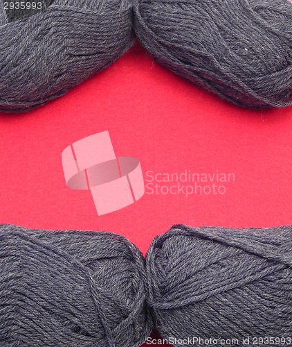 Image of Gray new wool as frame on red felt as background