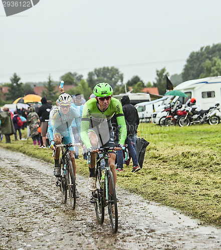 Image of Two Cyclsits on a Cobbelstoned Road in the Rain