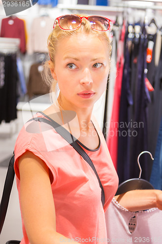 Image of Beautiful woman shopping in clothing store.