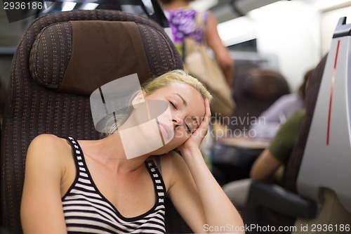 Image of Lady traveling napping on a train.