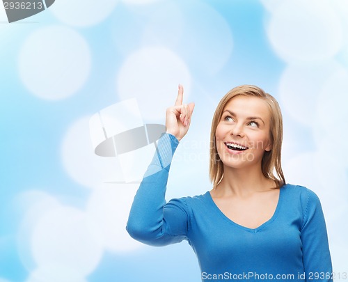 Image of smiling woman pointing her finger up