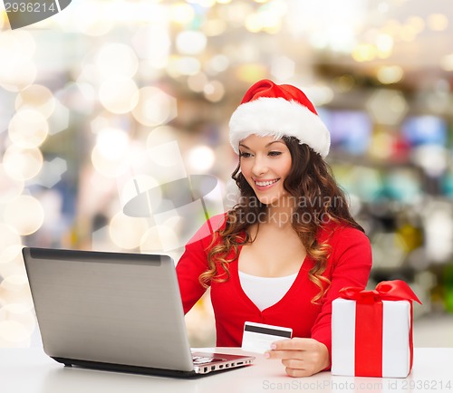 Image of smiling woman with credit card and laptop