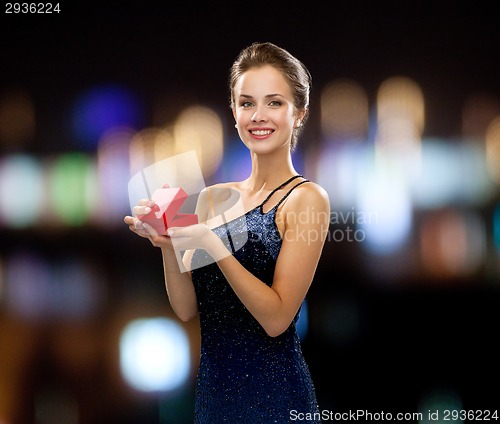 Image of smiling woman holding red gift box