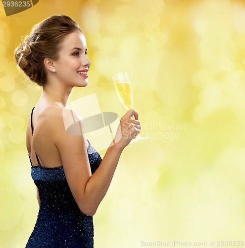 Image of smiling woman holding glass of sparkling wine