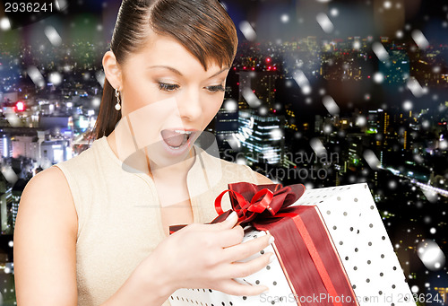 Image of smiling woman in red dress with gift box