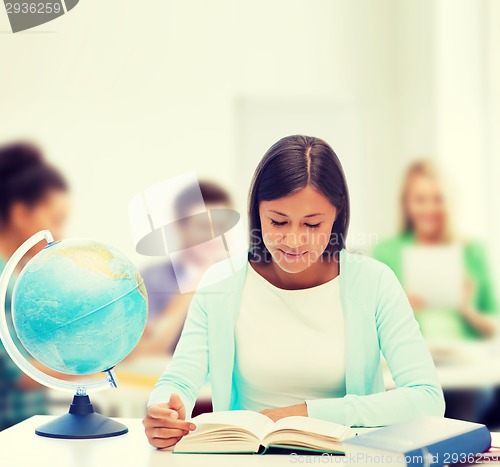 Image of teacher with globe and book at school