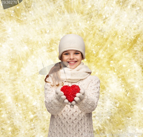 Image of dreaming girl in winter clothes with red heart