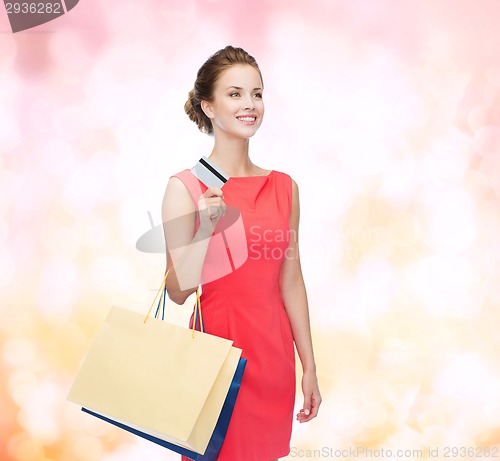 Image of smiling woman with shopping bags and plastic card