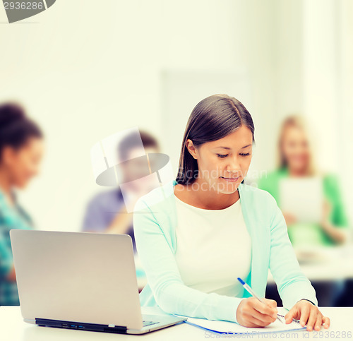 Image of asian businesswoman with laptop and documents