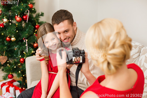 Image of mother taking picture of father and daughter