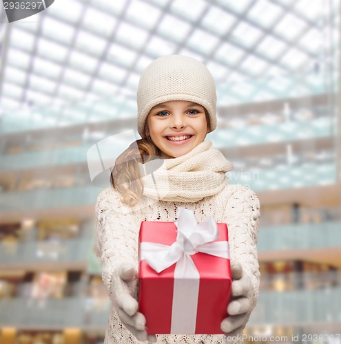Image of dreaming girl in winter clothes with gift box