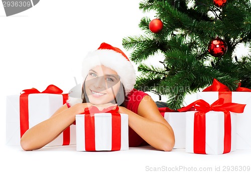 Image of smiling woman in santa helper hat with gift boxes