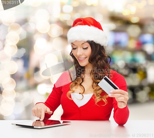 Image of smiling woman with credit card and tablet pc