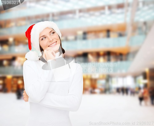 Image of thinking and smiling woman in santa helper hat