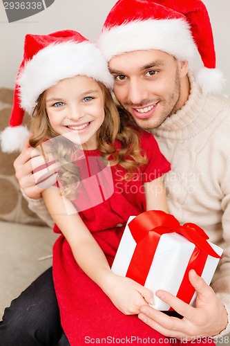 Image of smiling father and daughter holding gift box