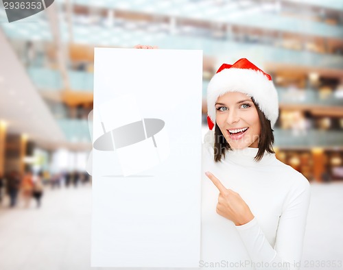 Image of smiling young woman in santa hat with white board