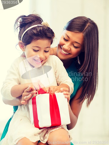 Image of happy mother and child girl with gift box