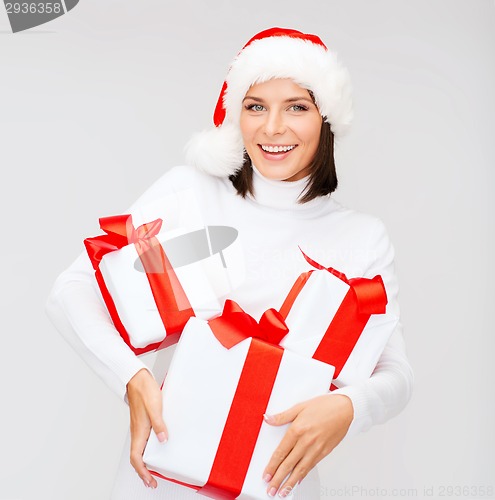 Image of woman in santa helper hat with many gift boxes