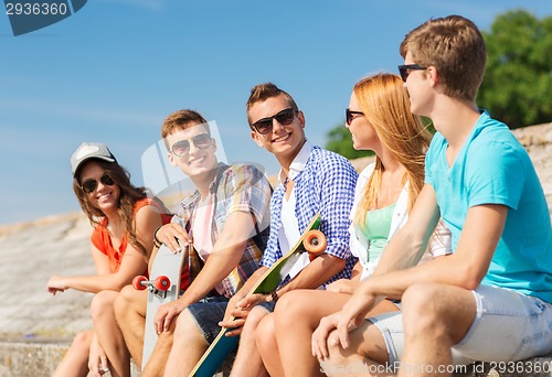 Image of group of smiling friends sitting on city street