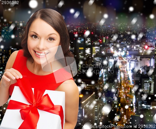 Image of smiling woman in red dress with gift boxes