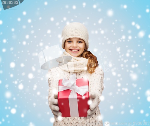 Image of girl in hat, muffler and gloves with gift box