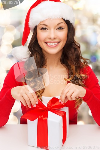 Image of smiling woman in santa helper hat with gift box