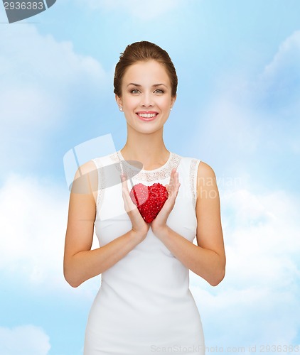 Image of smiling woman in white dress with red heart