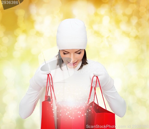 Image of smiling young woman with red shopping bags