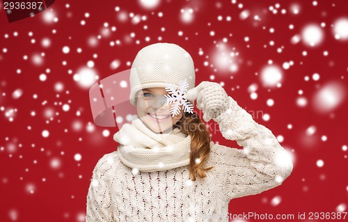 Image of smiling girl in winter clothes with big snowflake