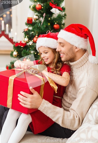 Image of smiling father and daughter opening gift box