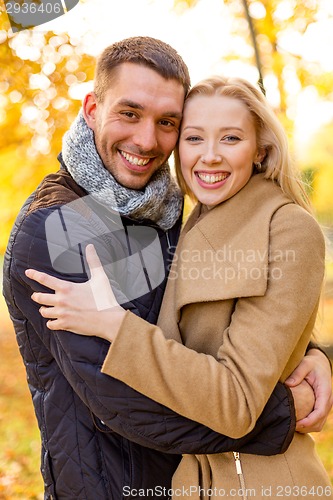 Image of smiling couple hugging in autumn park