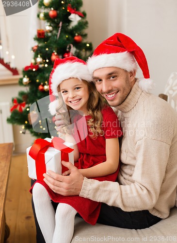 Image of smiling father and daughter holding gift box