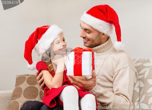 Image of smiling father giving daughter gift box