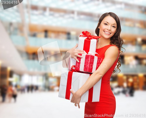 Image of smiling woman in red dress with gift boxes