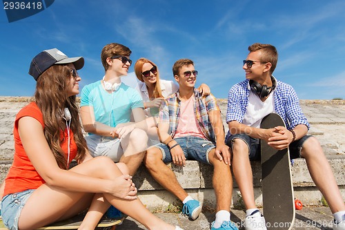 Image of group of smiling friends sitting on city street